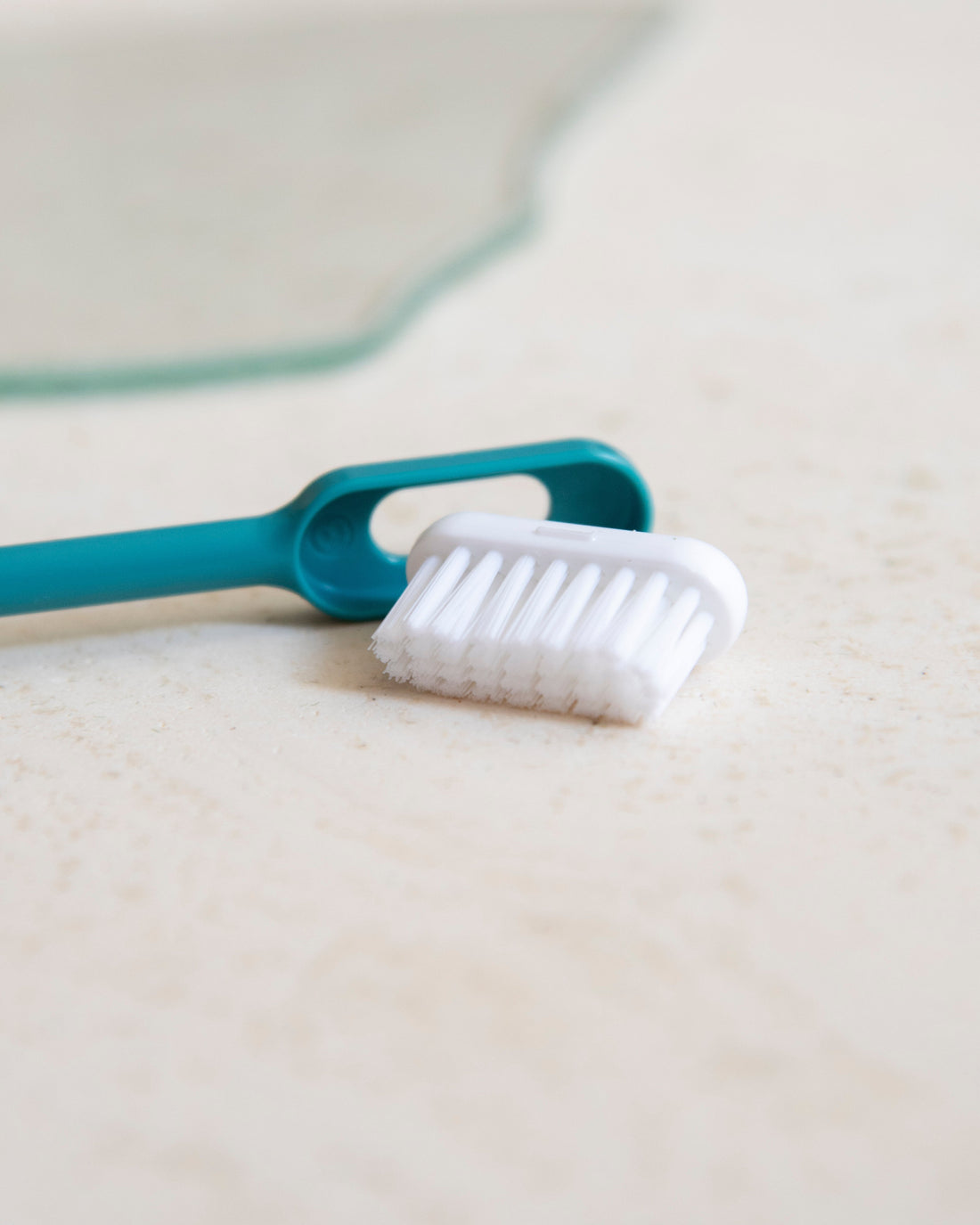 Brosse à dents turquoise dont la tête rechargeable est détachée du manche