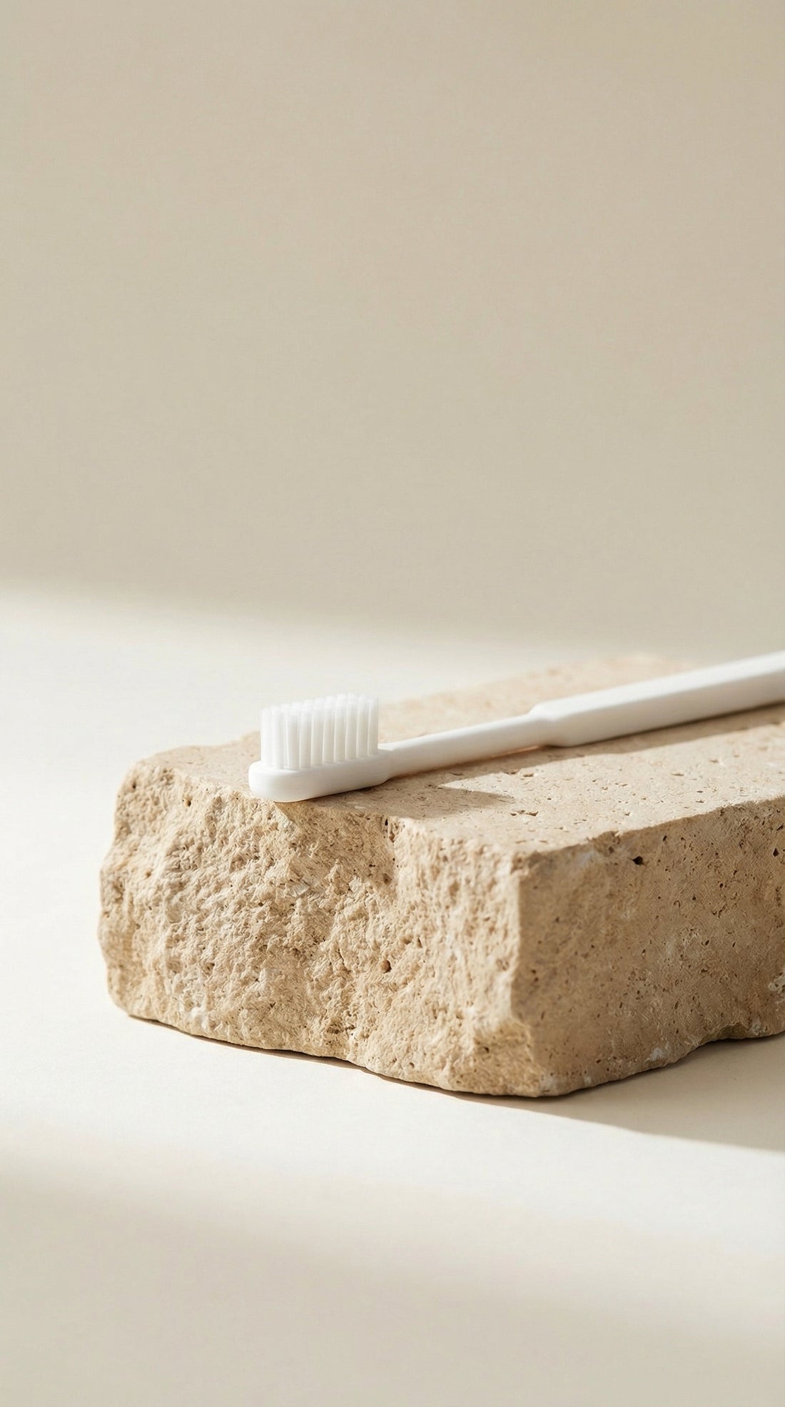Brosse à dents rechargeable blanche posée sur une pierre